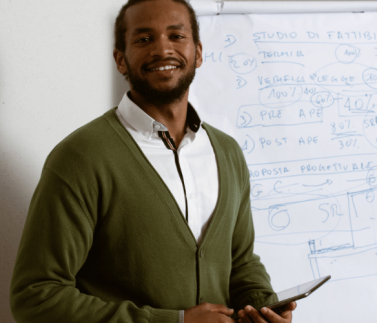 male teacher , holding a tablet device , white drawing chart