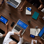 group of teachers , in the boardroom , laptops and mobile devices