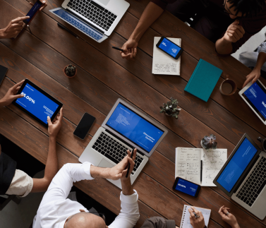group of teachers , in the boardroom , laptops and mobile devices